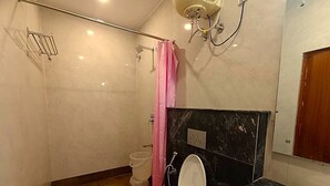 Ein Badezimmer mit Toilette, Waschbecken und Duschbereich.