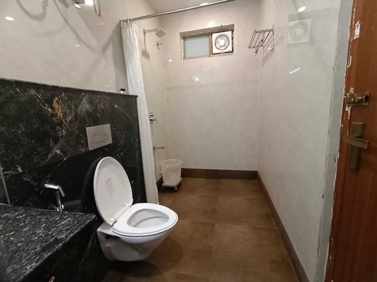 Une salle de bain comprenant des toilettes, un lavabo et un espace douche.