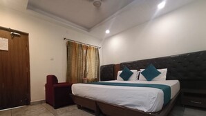 Ein Schlafzimmer mit Bett, Stuhl, Kleiderschrank und Vorhang.