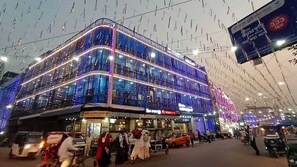 Un edificio de varios pisos con fachada curva, iluminado por luces colgantes.