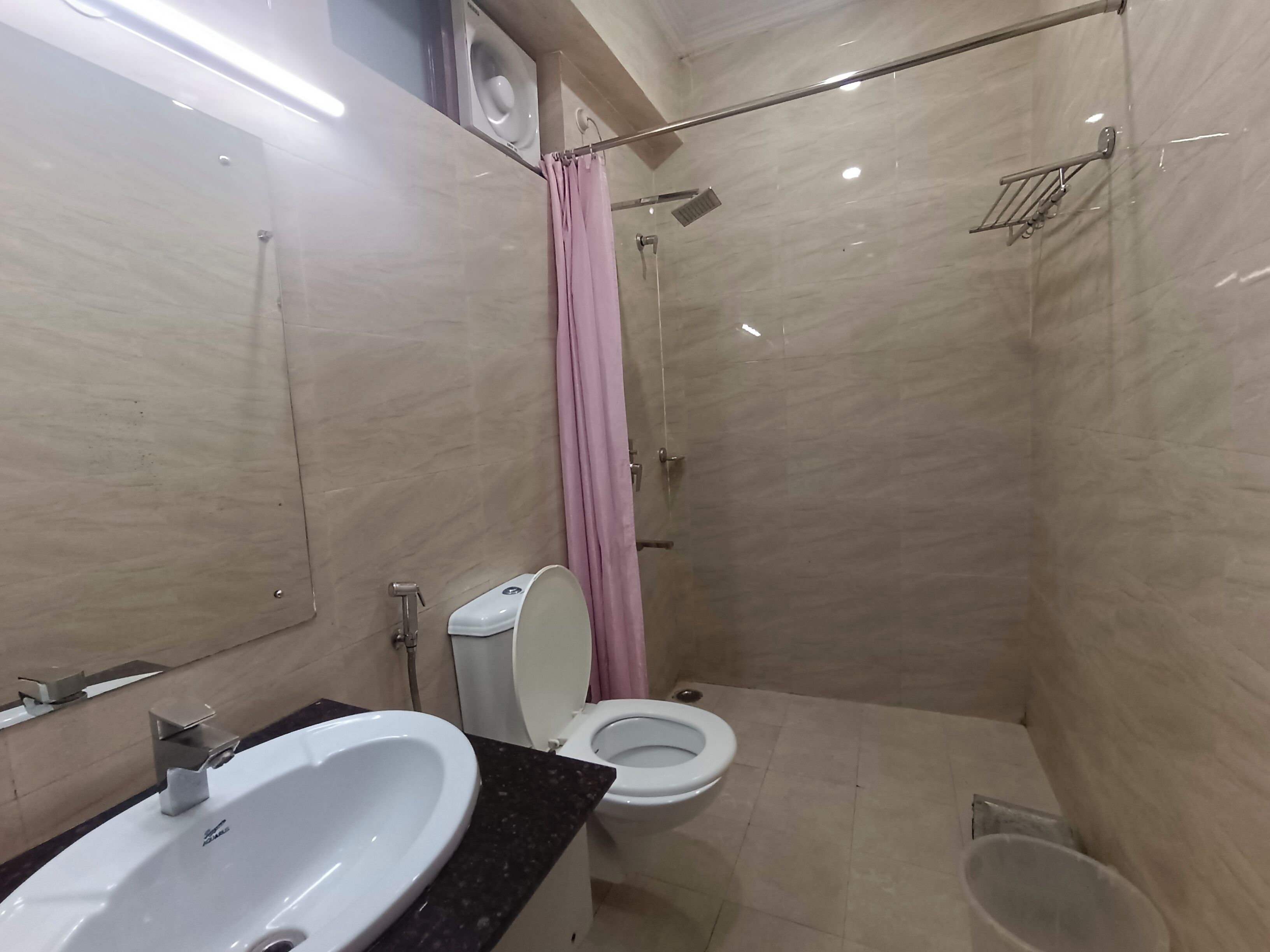A modern bathroom with a sink, toilet, and shower.