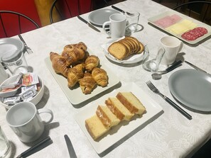 A breakfast table with croissants, bread, and cake. - B&B Puente de Órbigo (Hospital de Orbigo)