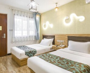 A hotel room with two beds, a wooden headboard, a bedside table with a phone, and a window with curtains. - Floral Hotel The Heroes Farmyard Beijing (Yanqing)