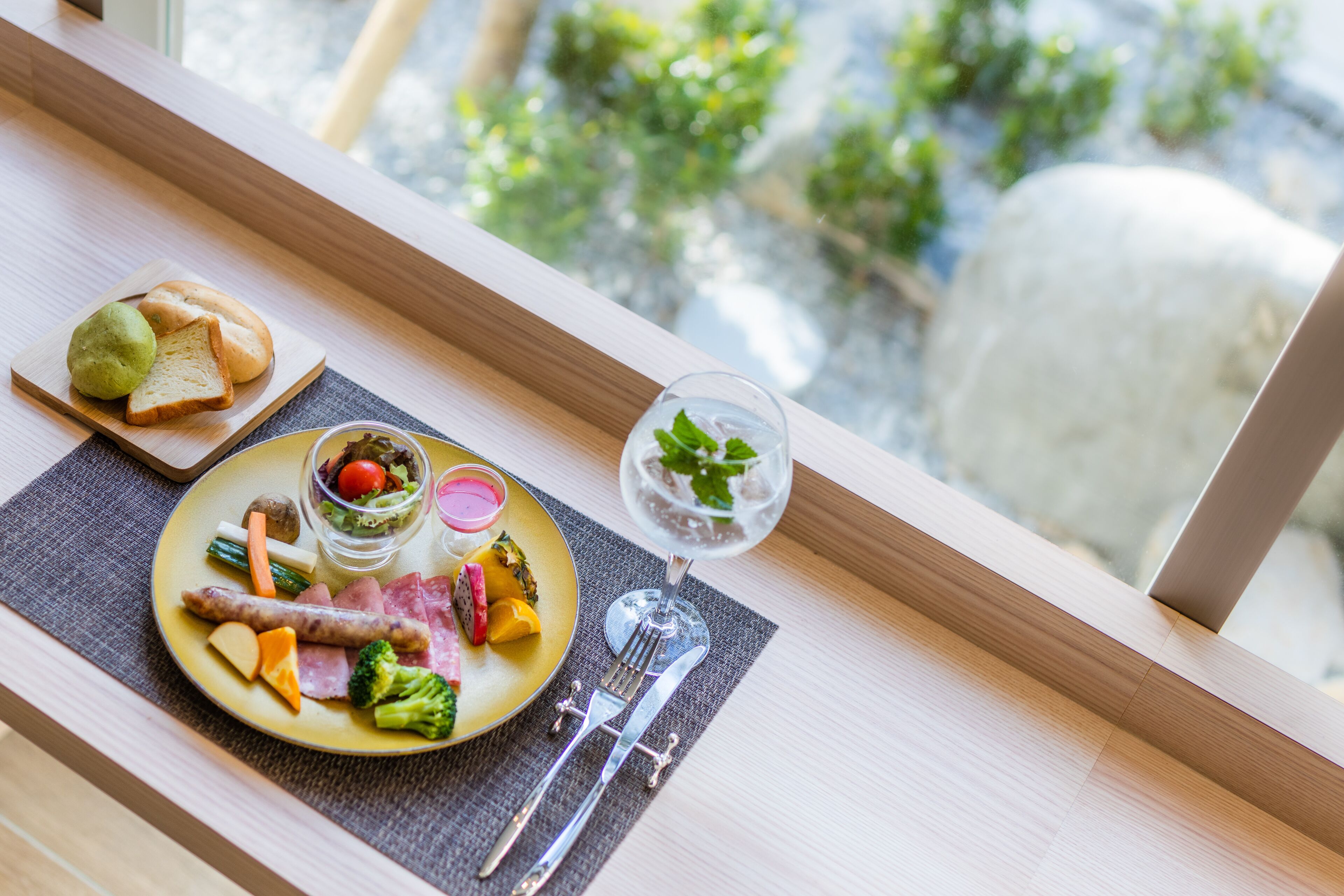 A dining table with a plate of food, a glass of water, and a fork and knife.