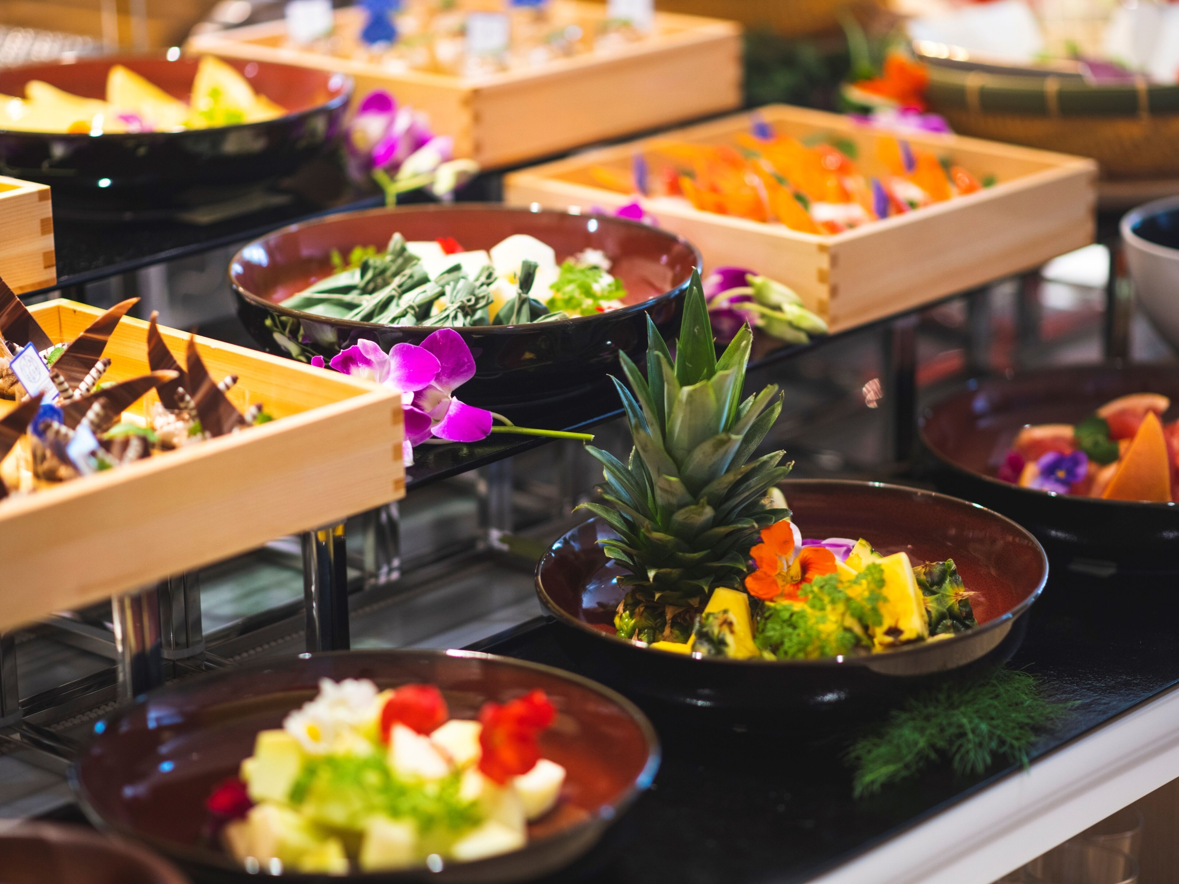 Un bufé con diferentes alimentos y flores frescas.