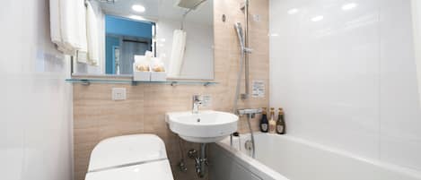 A modern bathroom with a white toilet, a sink, and a bathtub.