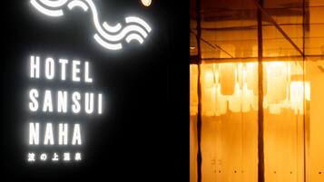 A hotel sign with the name "HOTEL SANSUI NAHA" and a wave design above the text.