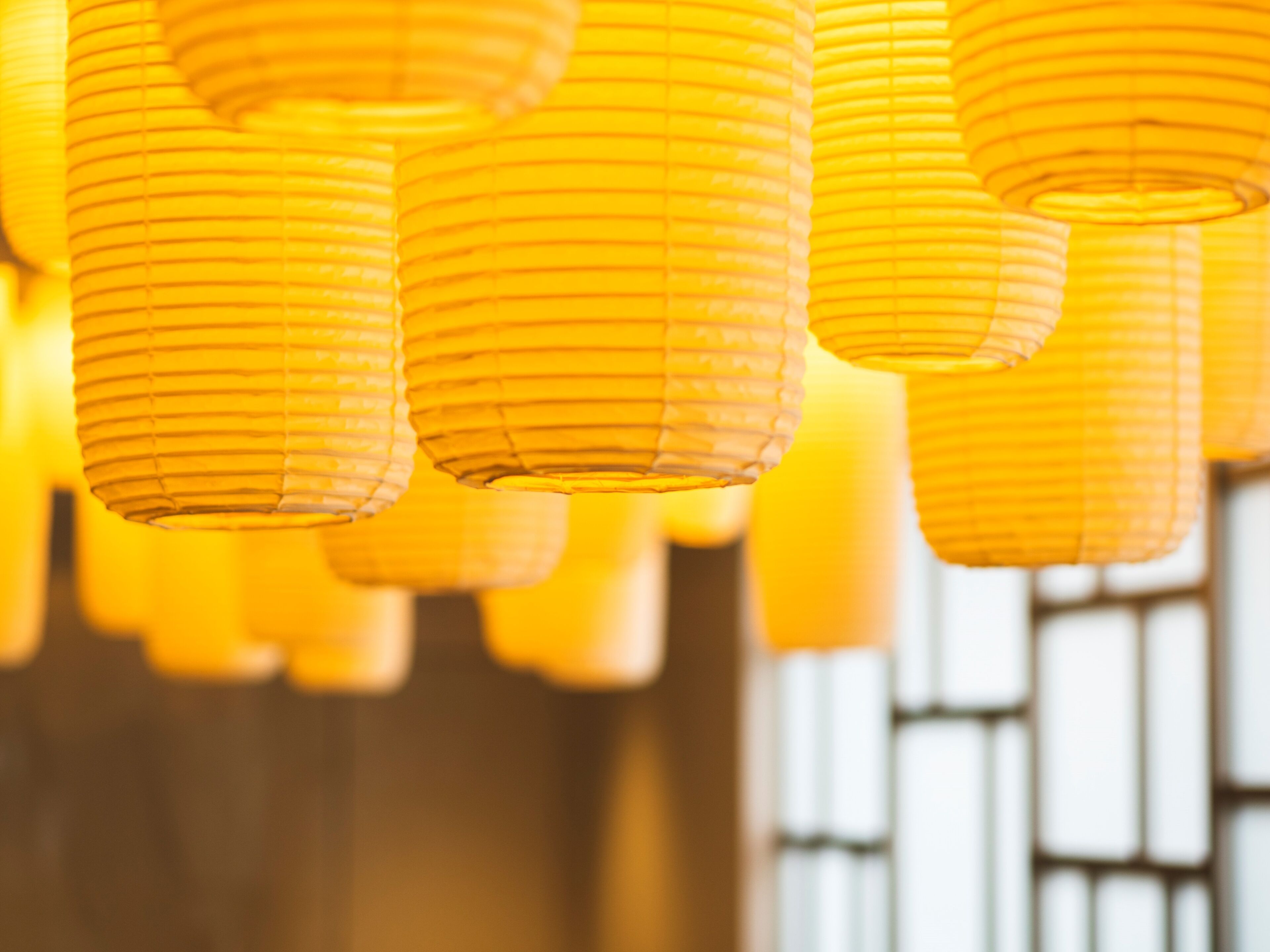 A row of hanging paper lanterns in a warm, dimly lit room.