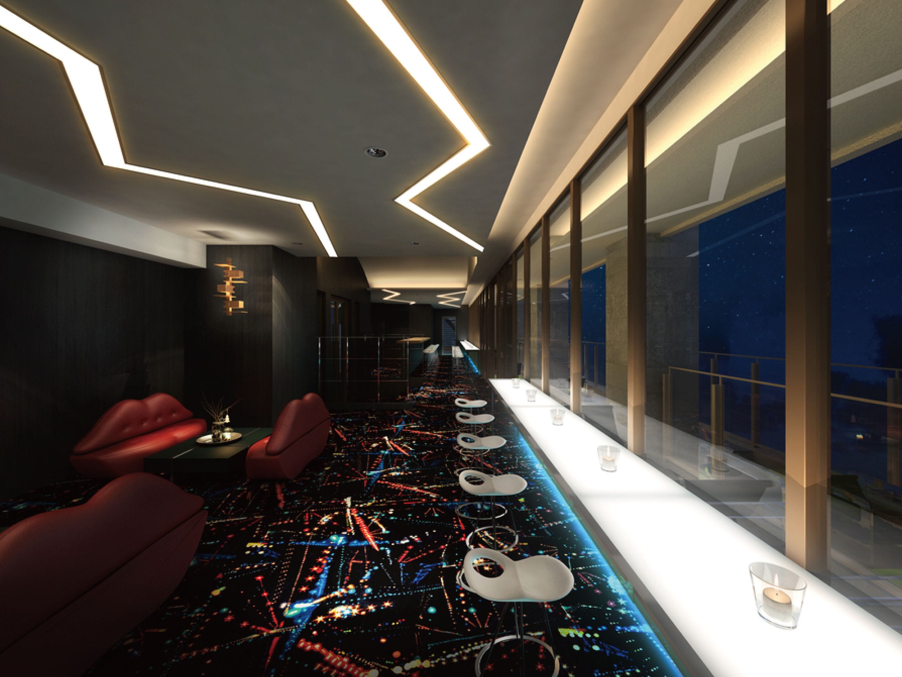 A modern hotel lobby with a long reception desk, seating area, and large windows offering a view of the night sky.