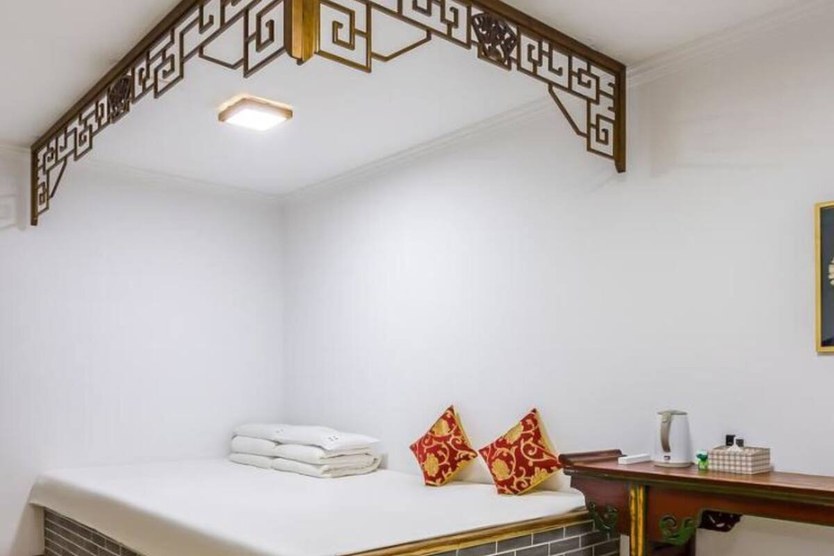 A hotel room with a bed, a desk, and a small table.