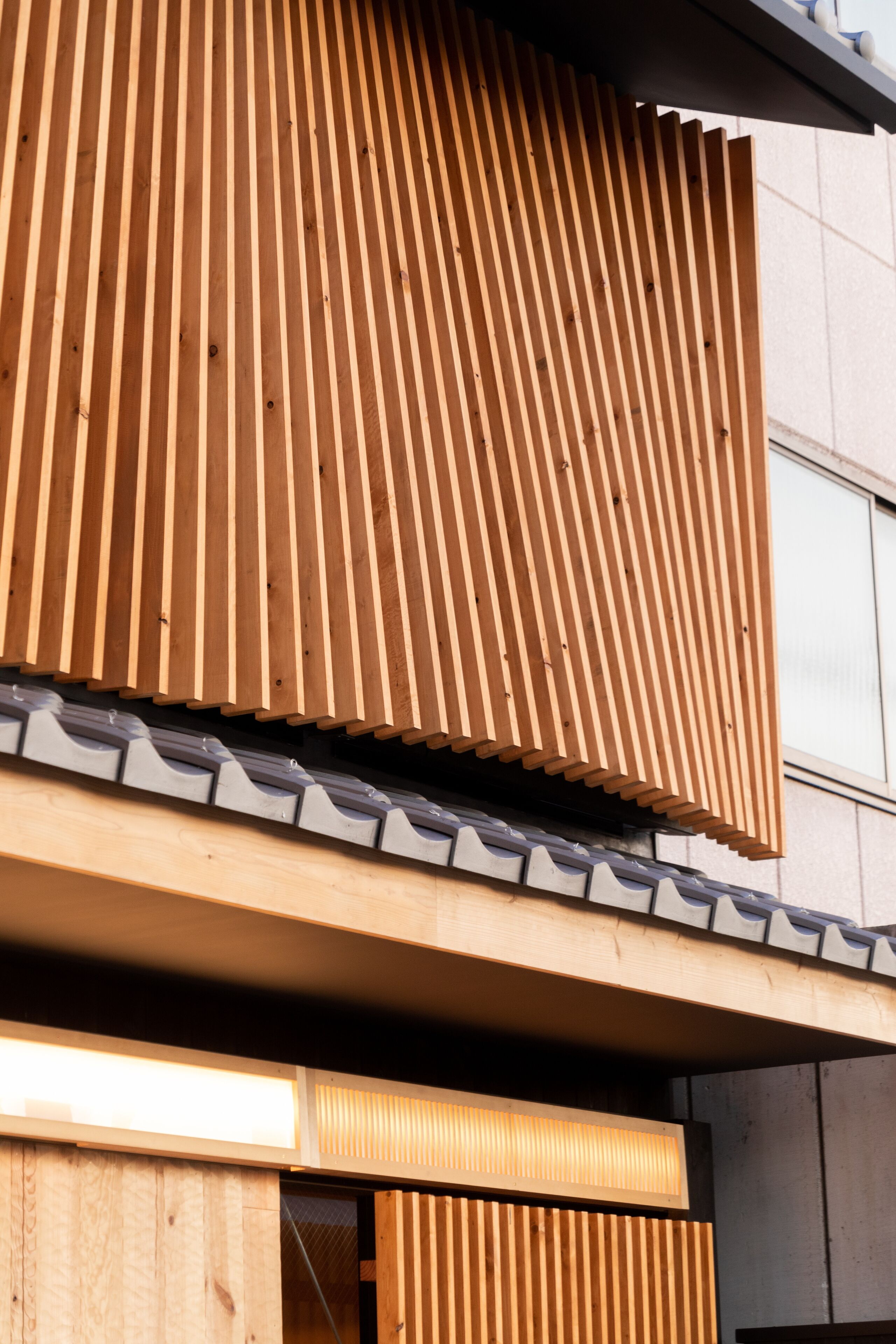 Ein modernes Gebäude mit einer Holzlamellenfassade und einem Flachdach.