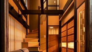 A traditional Japanese interior with a wooden bench, tatami flooring, sliding doors, and a staircase. - Kanade Matsubaragokomachi (Kyoto)