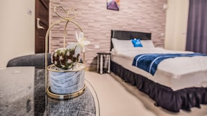 Ein Hotelzimmer mit einem Bett, einem kleinen Tisch mit einem Kaktus und einem Bild an der Wand.