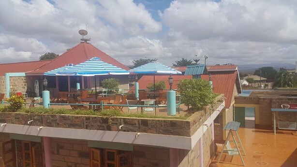 Une terrasse sur le toit, dotée d’un espace extérieur aménagé et de parasols à rayures.