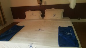 Une chambre d’hôtel avec un lit bien fait, deux oreillers et deux serviettes.
