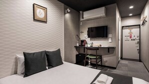 Une chambre d’hôtel équipée d’un lit, d’un bureau, d’une chaise et d’un téléviseur.