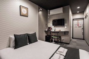 A hotel room with a bed, desk, chair, and a television. - Yuyu Ukiyoe Hotel (Osaka)