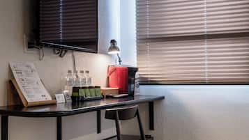 Un espacio de oficina moderno con un escritorio, una silla y un televisor de pantalla plana montado.