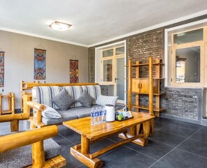 A cozy living room with a wooden sofa, a coffee table, and a wooden cabinet. - Floral Hotel Splendid Valley Beijing (Beijing)