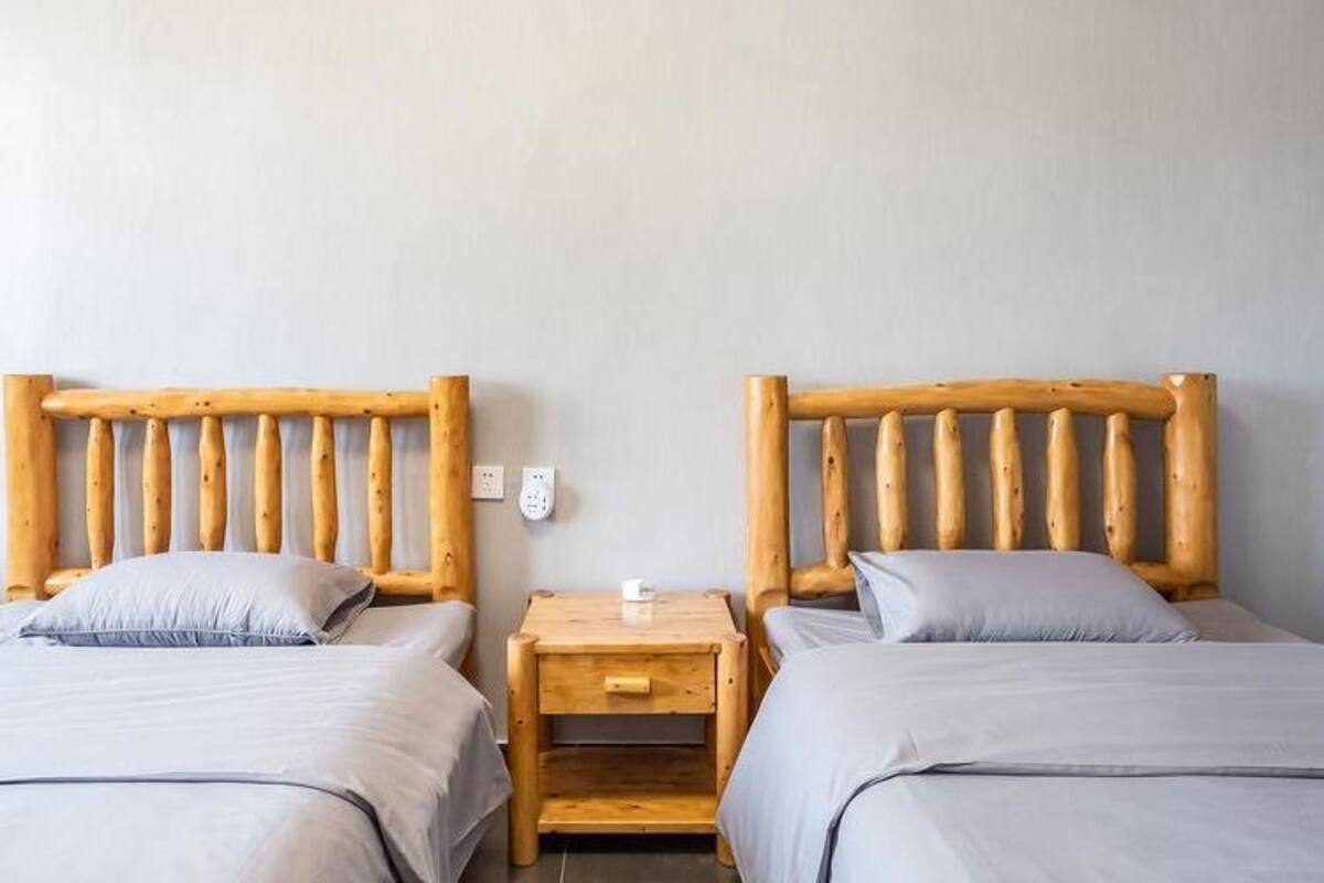 A twin room with two wooden beds, each with a nightstand and a small drawer.