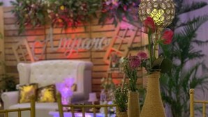 A dining area with a table set for a meal, featuring a decorative vase with flowers and a candle holder. - Nathaniel Hotel (Daet)