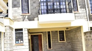 A two-story house with a balcony, large windows, and a paved driveway. - Valbras Homestay Nairobi (Syokimau)