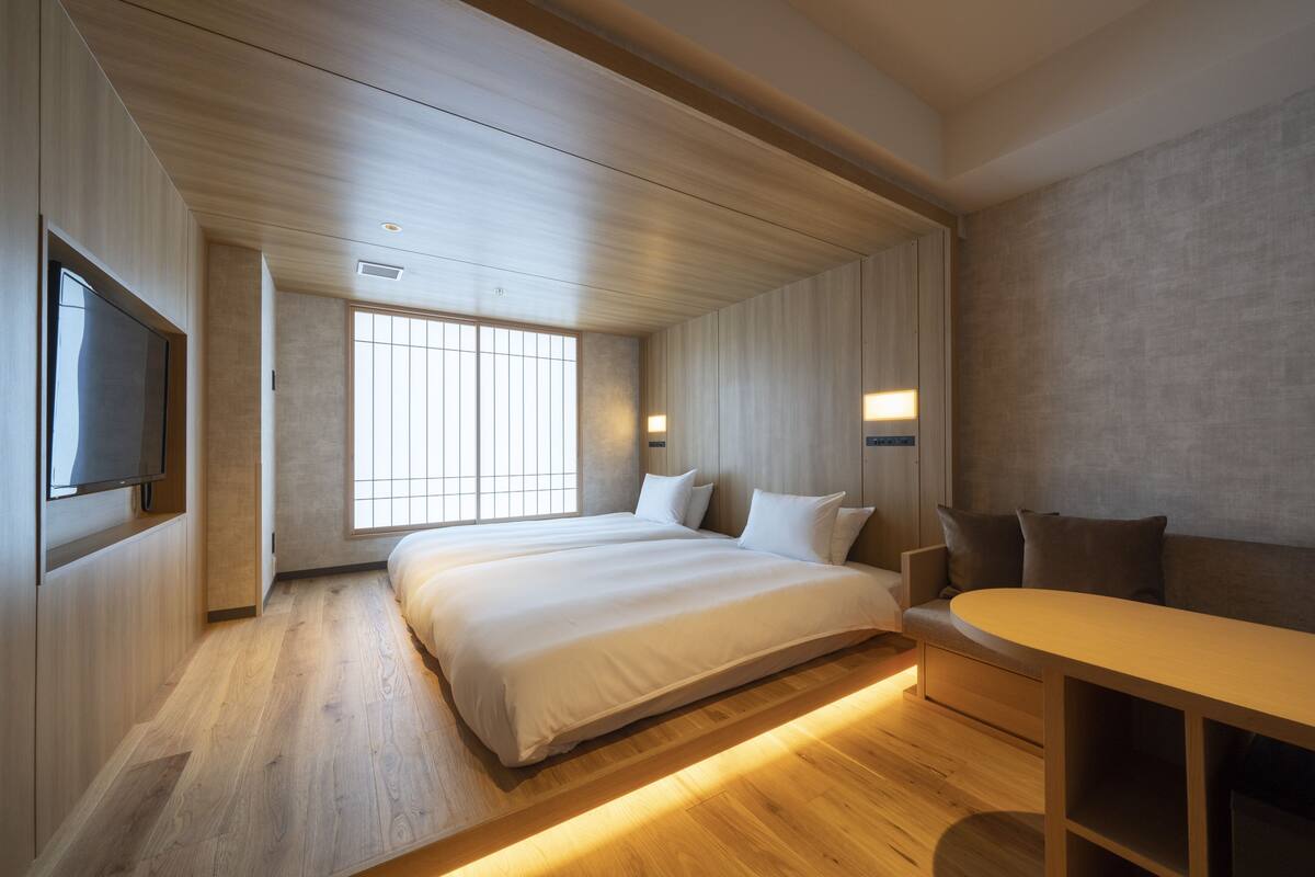 Una habitación de hotel moderna con una cama grande, una zona de estar y un televisor.