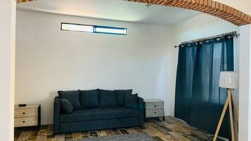 Suite estudio familiar | Área de sala de estar | Televisión de 40 pulgadas con canales por cable