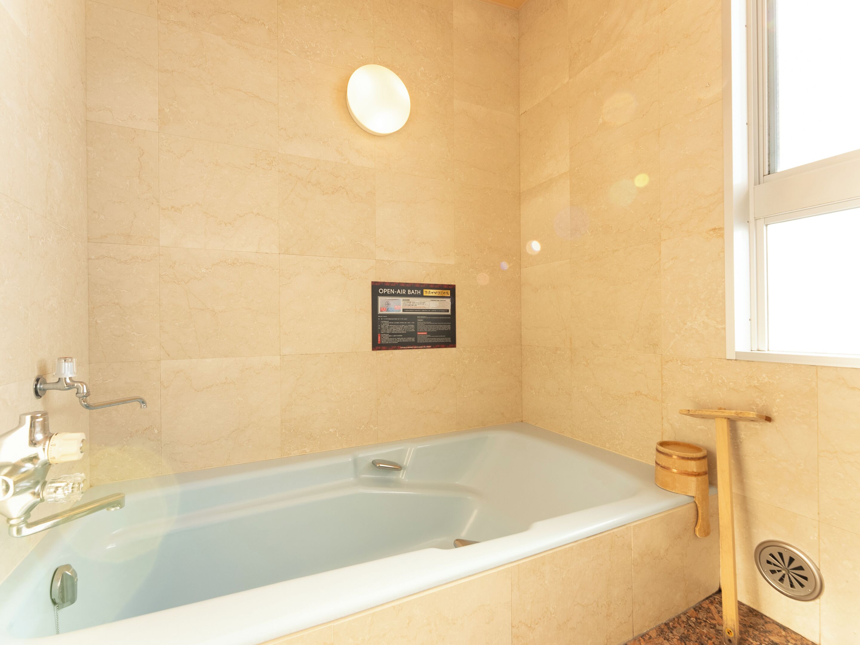 Un baño con bañera, ducha de mano y ventana.