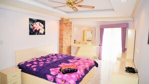 Ein Schlafzimmer mit Bett, Schminktisch, Kommode und Deckenventilator.