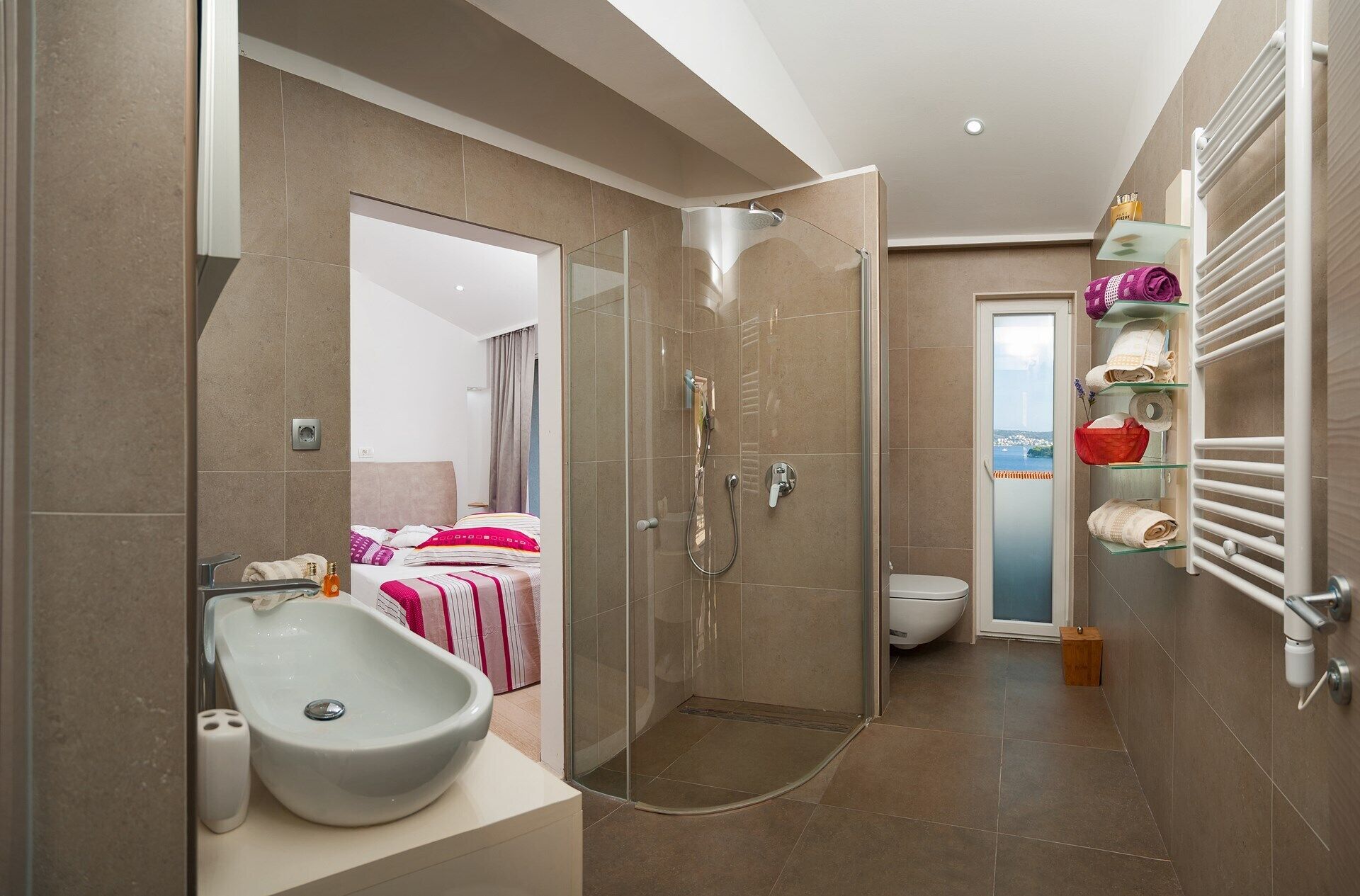 A modern bathroom with a glass-enclosed shower, a white sink, and a toilet.