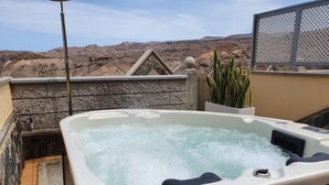 A hot tub with a stone wall backdrop and a mountainous view. - Las Brisas de Puerto Rico (Mogán)