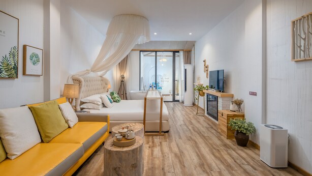 A modern living room with a sofa, a coffee table, a fireplace, and a television. - Floral Hotel Yipin Visual Arts Xitang (Jiaxing)