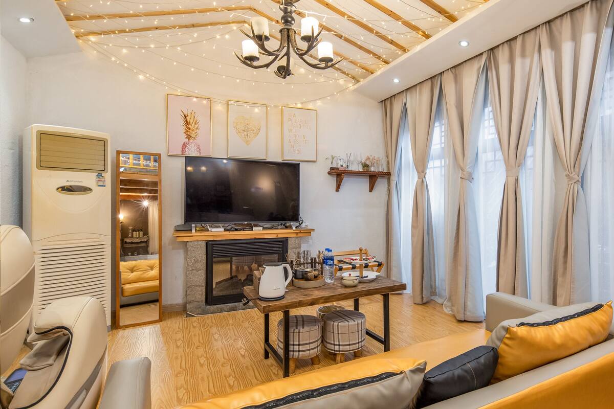 Una sala de estar moderna con un televisor de pantalla plana, una chimenea y un rincón de asientos acogedor.