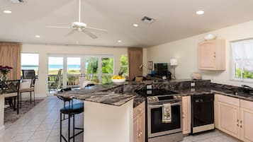 A modern kitchen with a central island, built-in oven, and dishwasher.