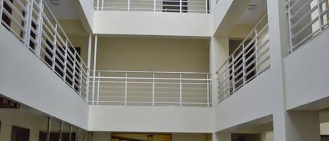 A multi-level atrium with a central open space, white railings, and a hanging chandelier.
