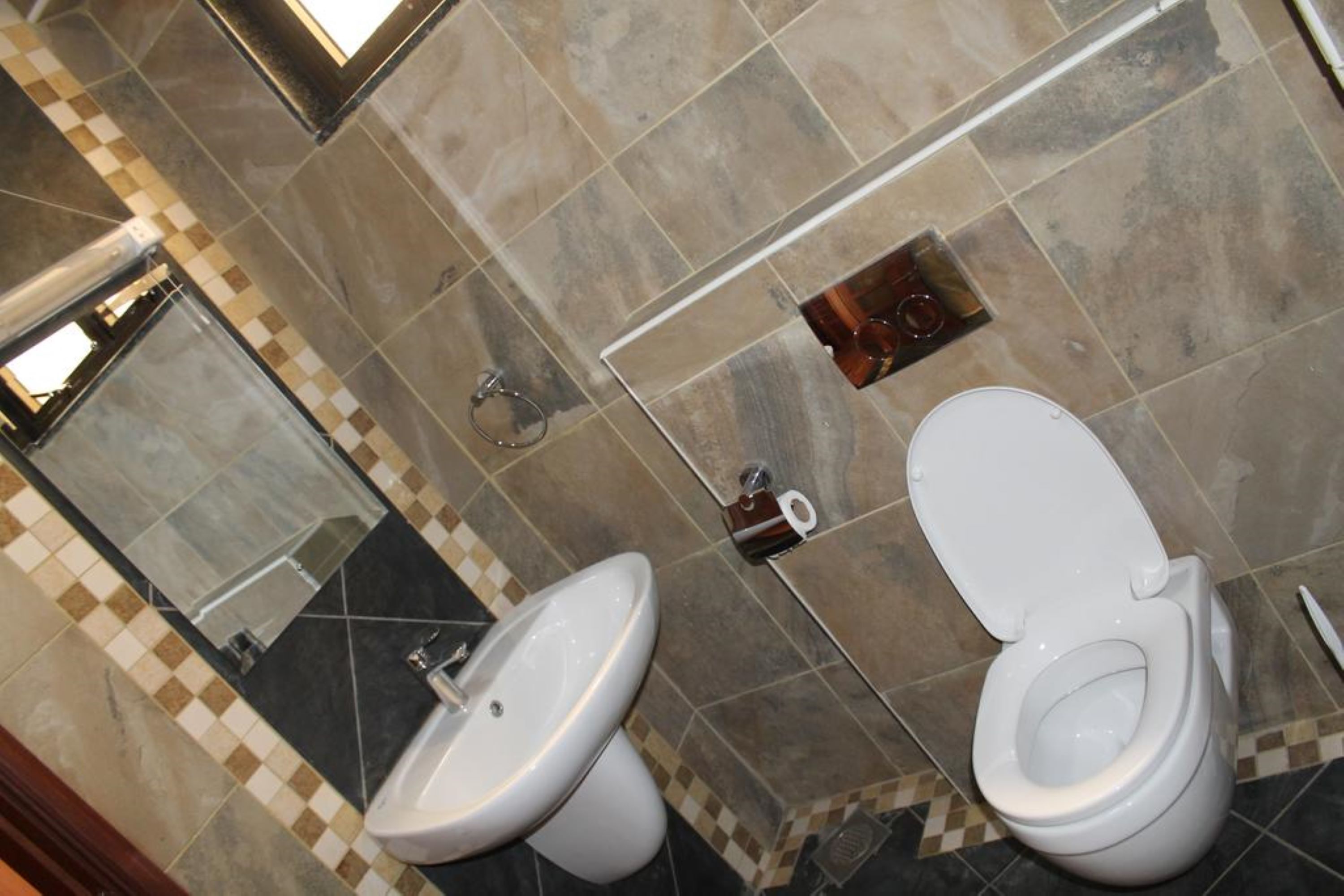 Un bany amb dues vàteres, un lavabo i un mirall.