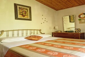 A bedroom with a bed, a wooden headboard, a dresser, a mirror, and a framed picture on the wall.