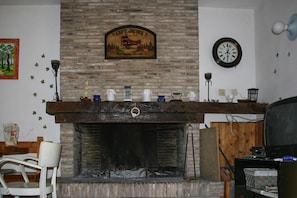 A fireplace with a stone mantle, a clock, and a sign above it. - Farmhouse in Fano with Pool & Adriatic Views (Colli al Metauro)