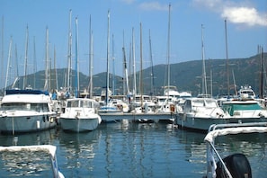 Boats docked in a serene marina surrounded by hilly landscape.