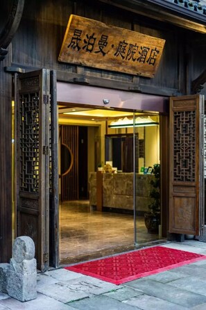 A traditional wooden building with a sign indicating it is a hotel.