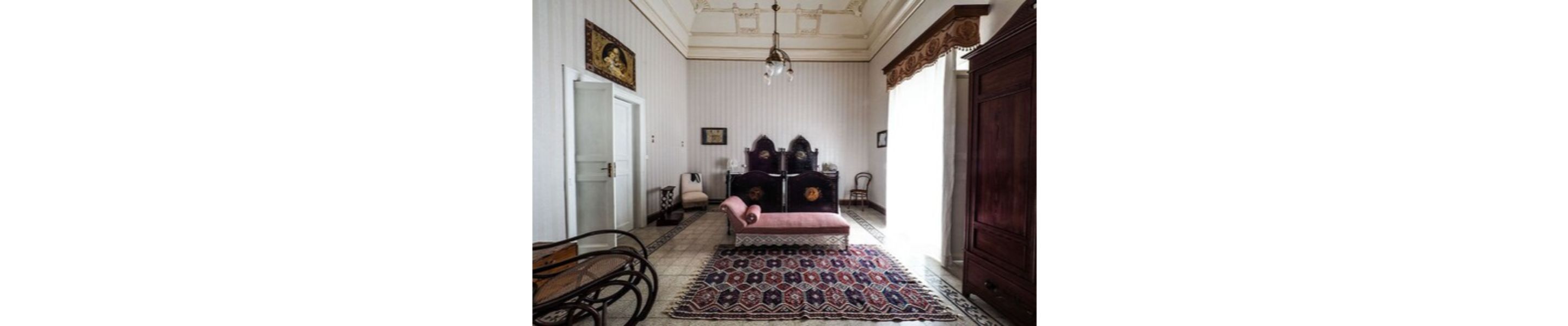 Une pièce comprenant un lit, une chaise, une table et un tapis à motifs.