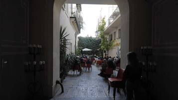 An outdoor seating area with tables and chairs, surrounded by buildings.