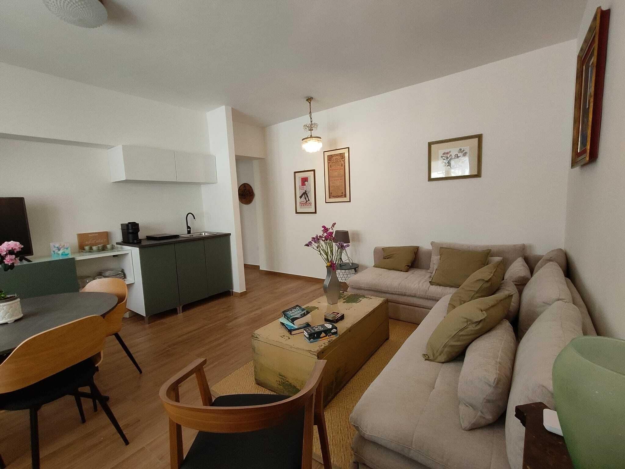 A compact living space with a kitchenette, a dining area, and a sofa.