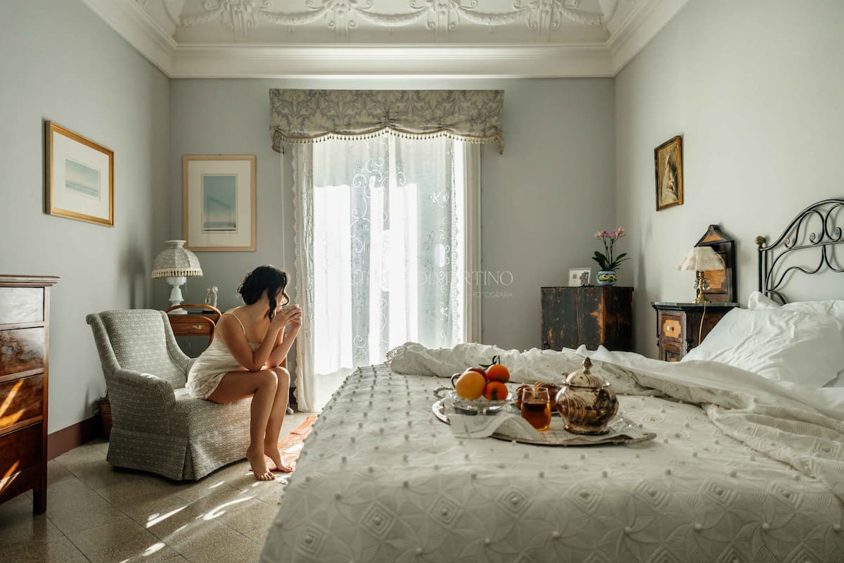 Une chambre à coucher comprenant un lit, une chaise, une table de chevet et une commode.
