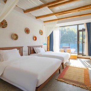A hotel room with two beds, a balcony with a view, and decorative plates on the wall. - Huisen Huishe Guesthouse (Jinhua)