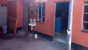 A red building with a sign reading "Food Joint" and a door leading inside.