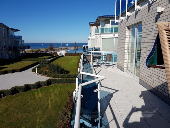 A modern hotel with a balcony overlooking a marina and the sea. - (147) 2-room apartment - apartment complex Residenz Am Yachthafen (Kühlungsborn)