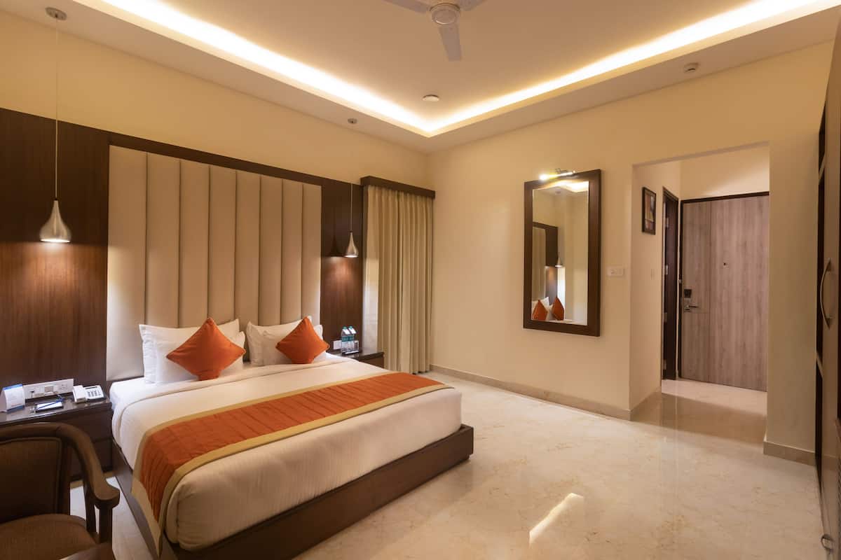 Una habitación de hotel moderna con una cama grande, un escritorio y una silla.
