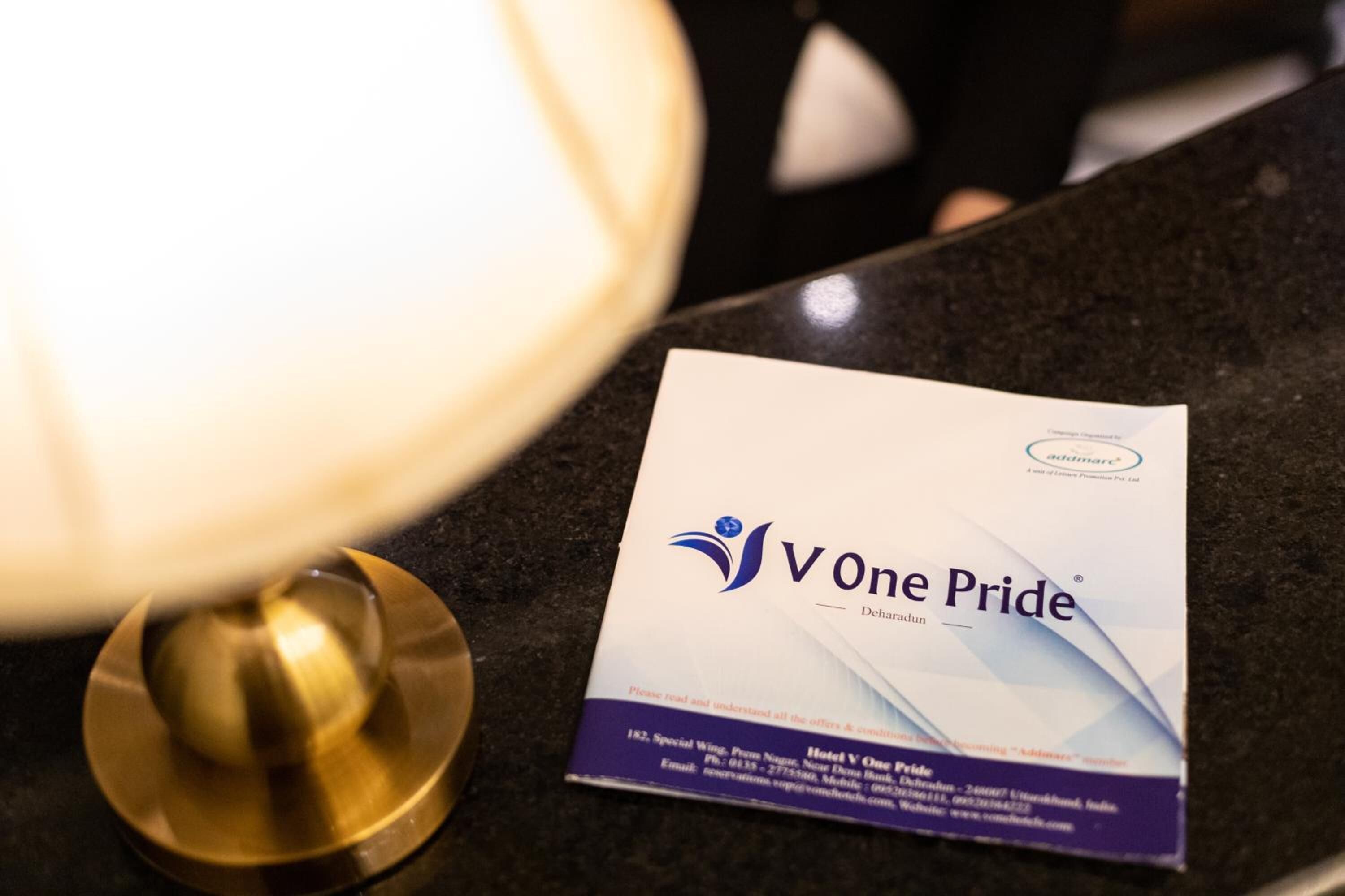 Eine Visitenkarte für das Hotel 'V One Pride' in Dehradun.